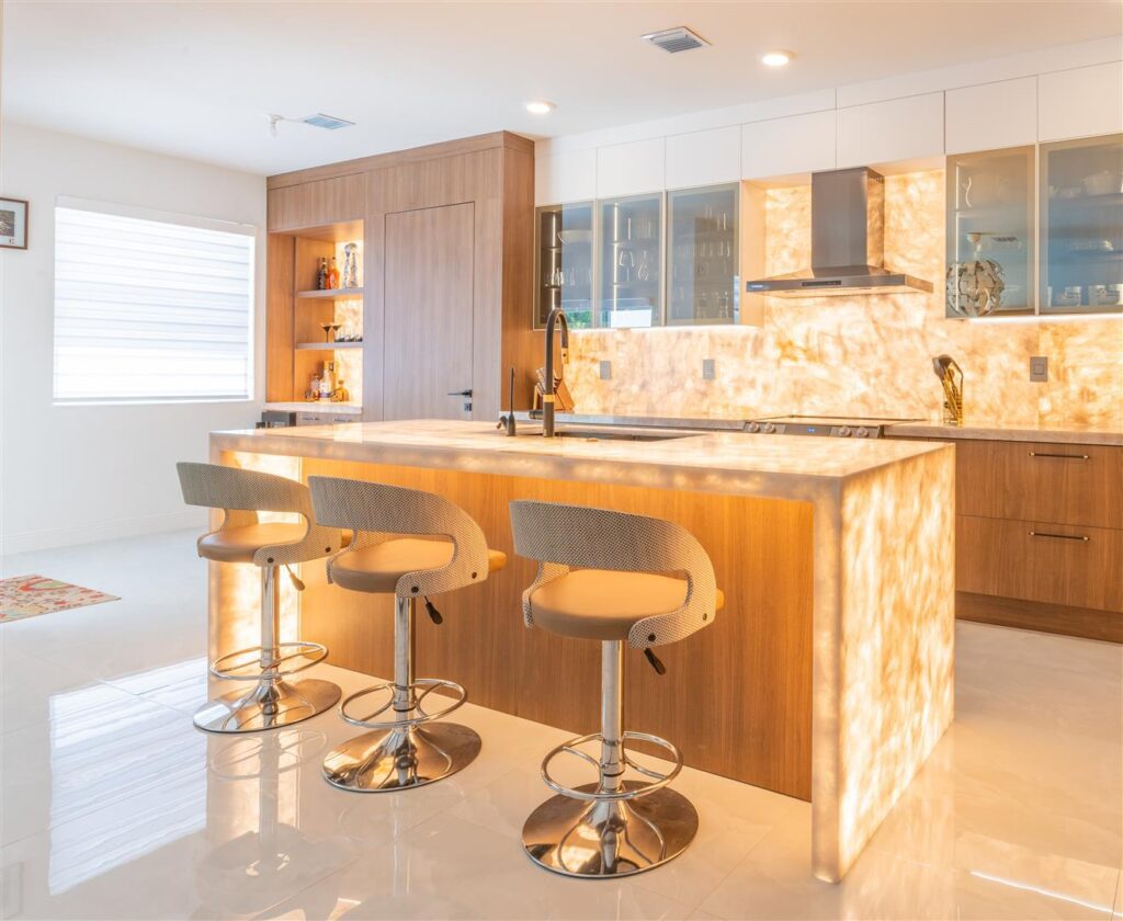 A modern kitchen with a large island and bar stools.