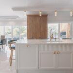 Design a modern kitchen with white cabinets and a large island.