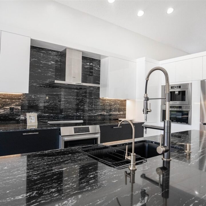 A Pembroke Pines kitchen with elegant black granite counter tops and sleek stainless steel appliances.