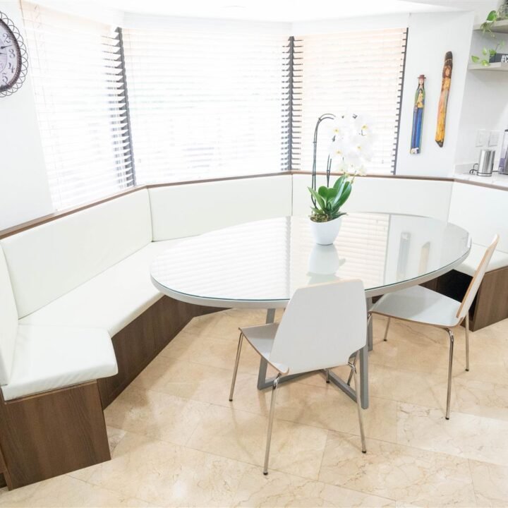 A Coral Gables kitchen with a modern table and chairs and a sleek clock.