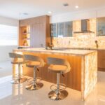 A modern kitchen with a large island and bar stools.