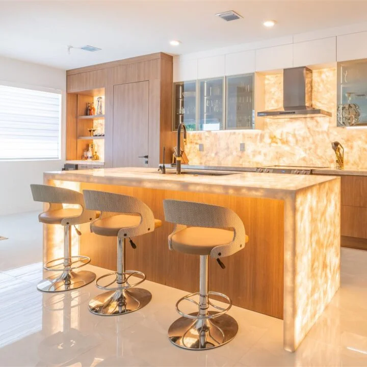 A modern kitchen with a large island and bar stools.