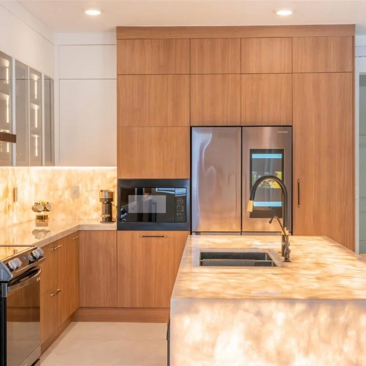 A kitchen with marble counter tops and stainless steel appliances.