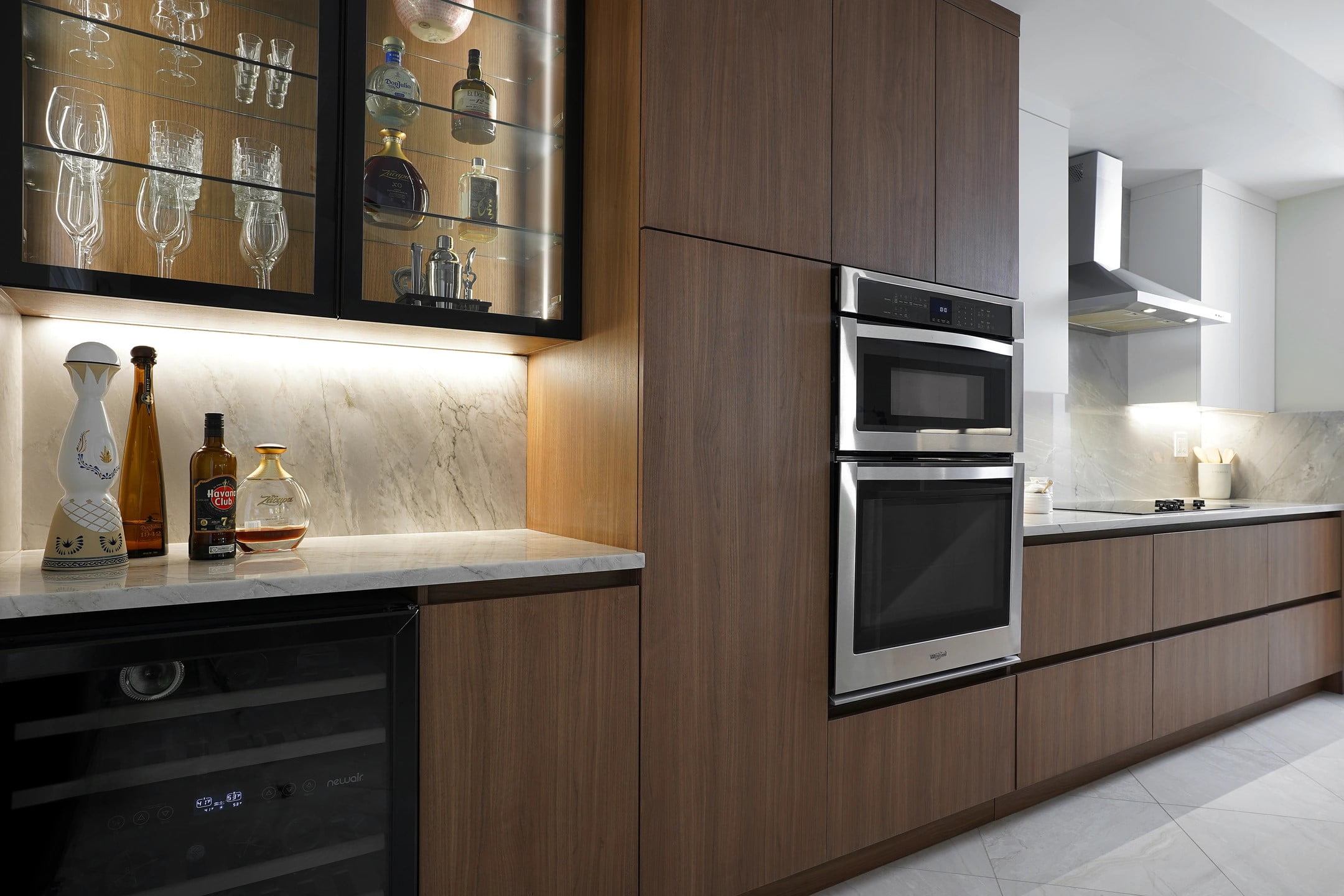 A modern kitchen with trendy wooden cabinets and a sleek glass door.