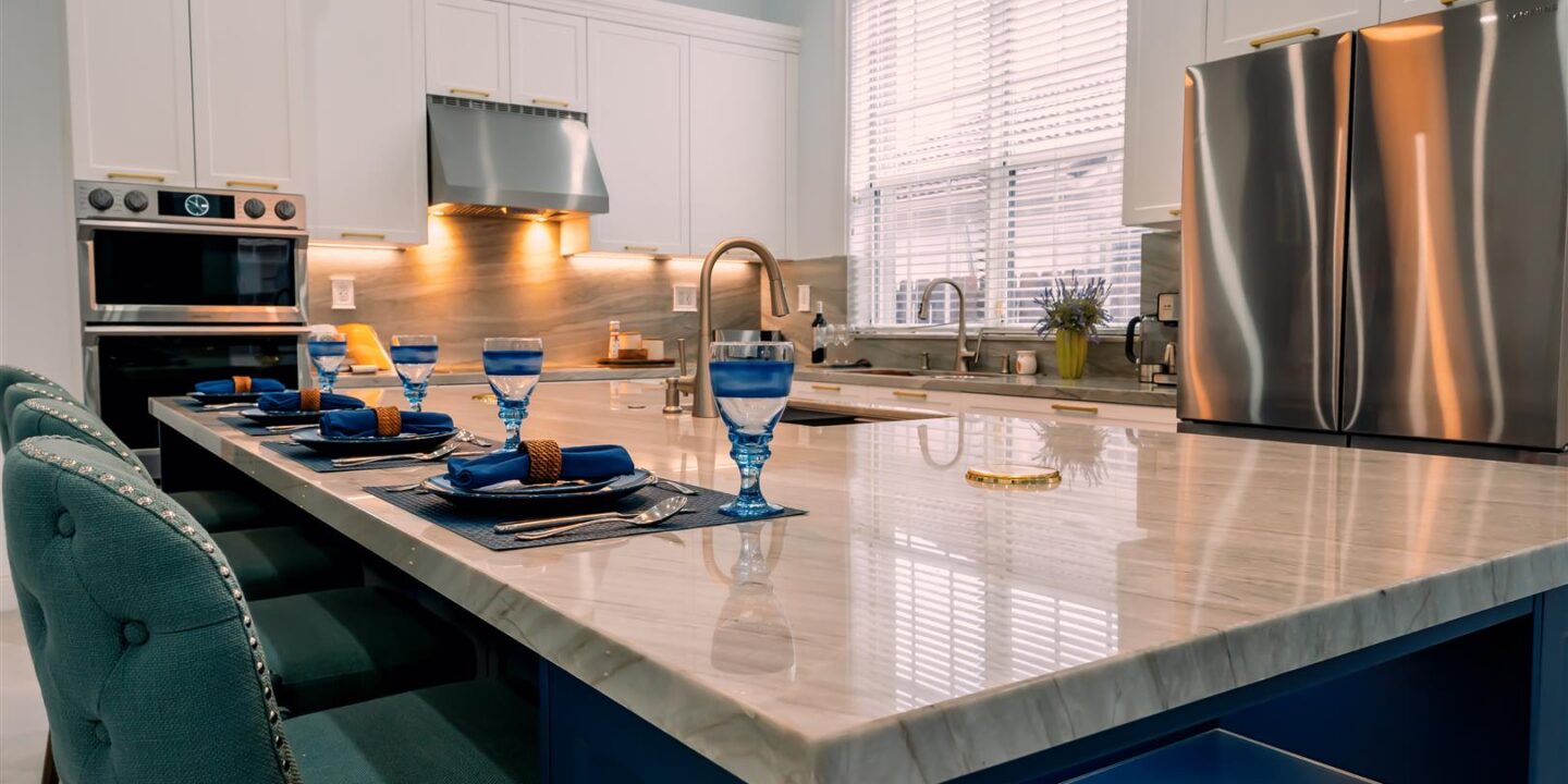 A kitchen with a blue island and blue chairs.