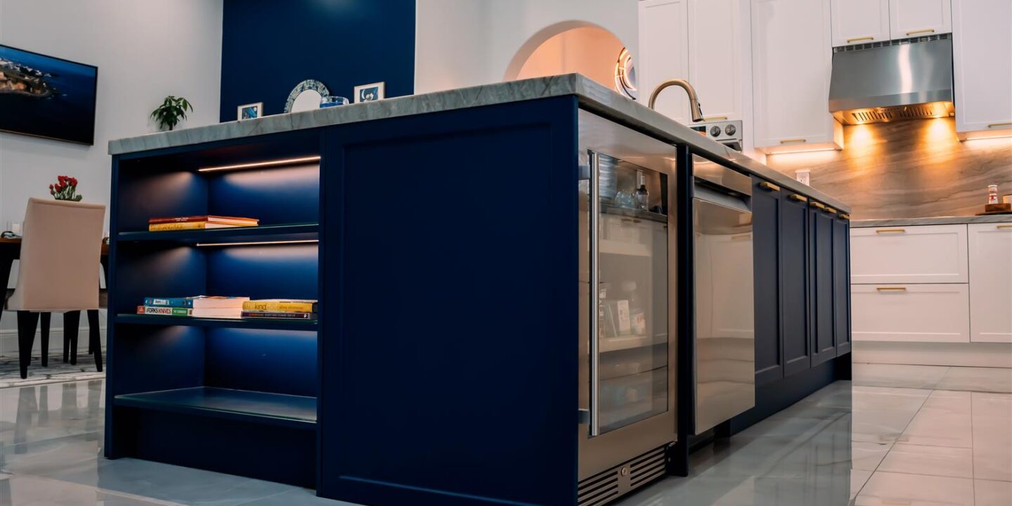 A kitchen with white cabinets and a blue island.