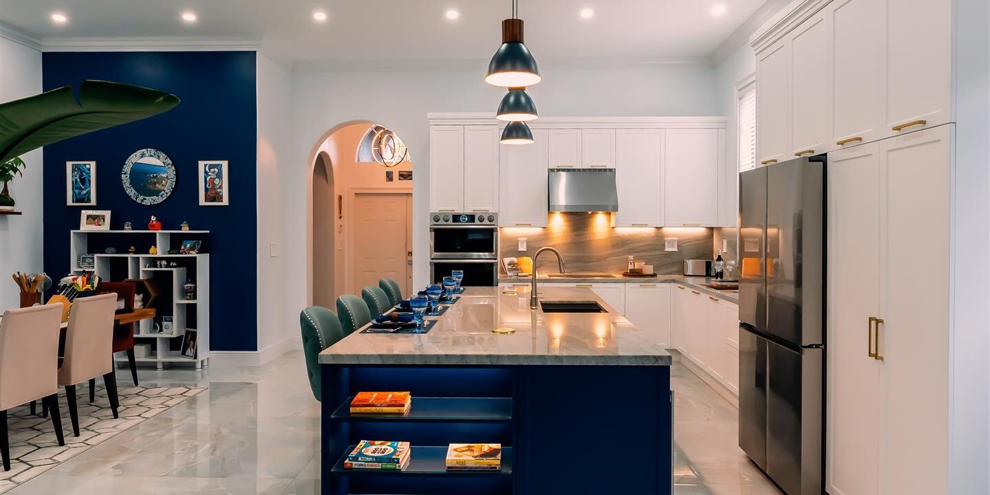 A kitchen with blue walls and white cabinets.