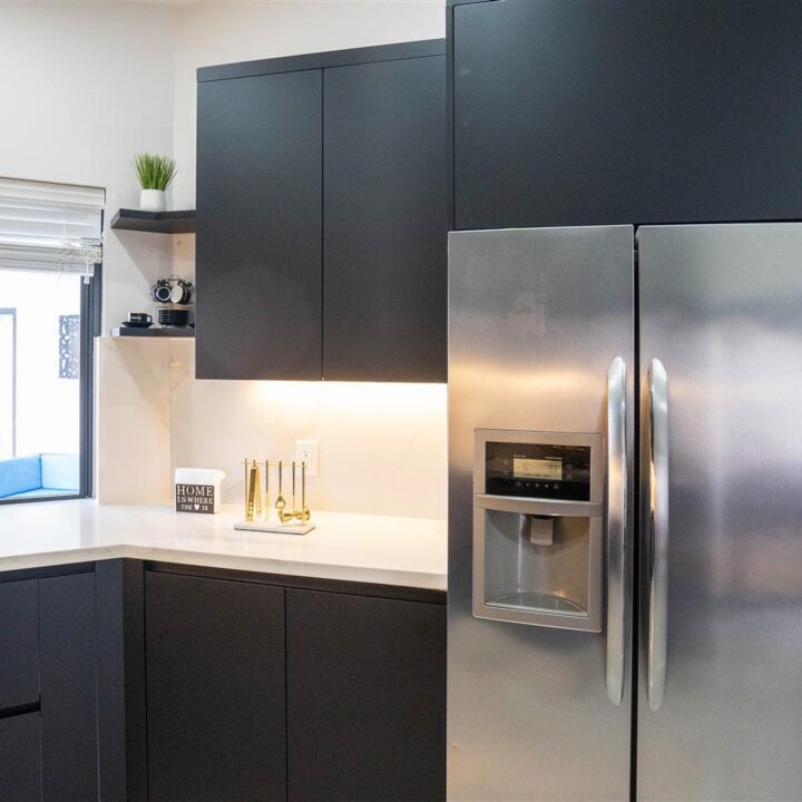 Pembroke Pines Residence Kitchen with black cabinets and stainless steel appliances.