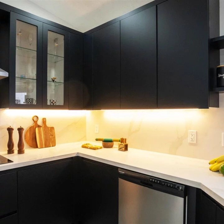 Pembroke Pines Residence with a custom kitchen featuring black cabinets and stainless steel appliances.